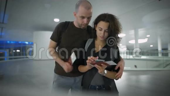 一对年轻夫妇在谈论机场的旅行视频的预览图