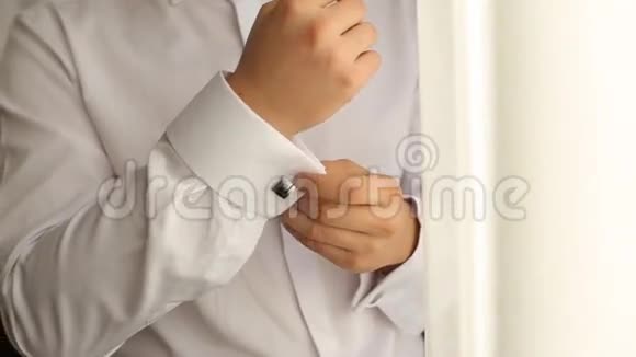 一个男人如何穿衬衫和袖扣的特写男人穿着婚礼视频的预览图
