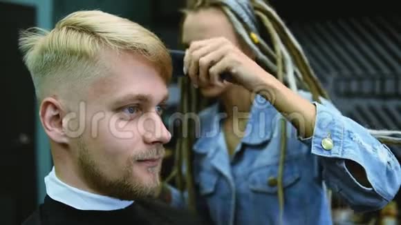 理发师在沙龙里用剪刀剪一个留胡子的人视频的预览图