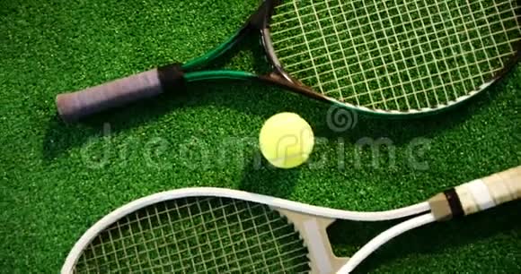网球和球拍布置在草地上视频的预览图