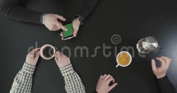 在另一个人把茶倒在杯子里的时候上面的手显示了手机的屏幕视频的预览图