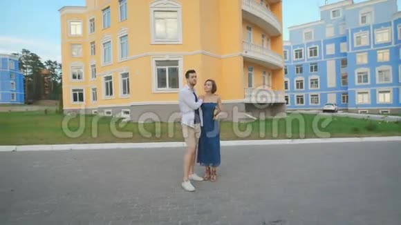 美丽的一对情侣迷上了年轻人牵着手在美丽的住宅区里散步视频的预览图