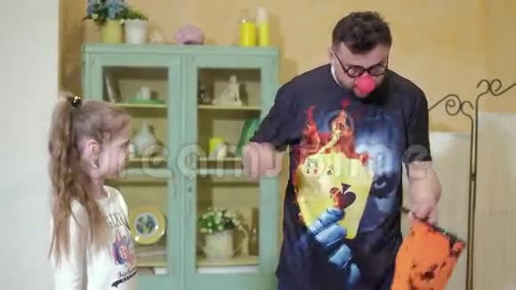 小丑用一根魔杖和一个包给女孩看一个魔术视频的预览图