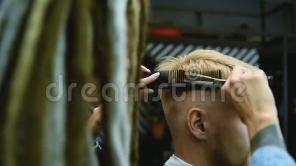 理发师在沙龙里用剪刀剪一个留胡子的人视频的预览图
