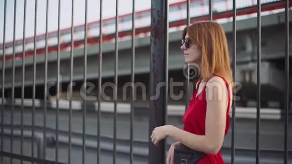 一幅漂亮的年轻红发女人的肖像穿着红色的裙子在日落时玩得很开心慢动作视频的预览图