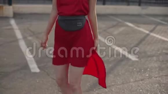一幅漂亮的年轻红发女人的肖像穿着红色的裙子在日落时玩得很开心慢动作视频的预览图