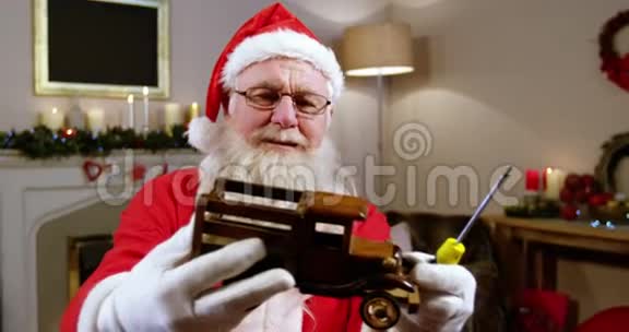 圣诞老人抱着玩具车看着视频的预览图