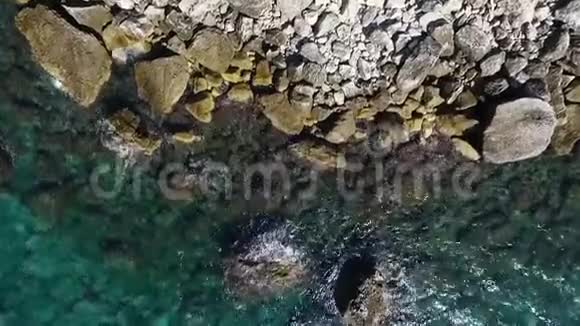 海浪撞击海岸线岩石的鸟瞰图视频的预览图