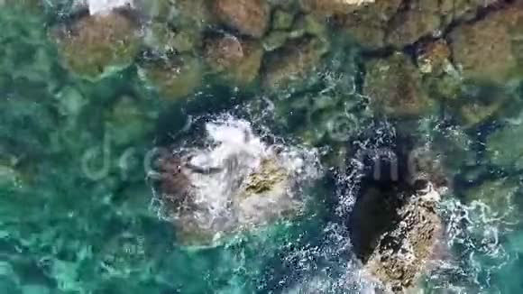 海浪撞击海岸线岩石的鸟瞰图视频的预览图