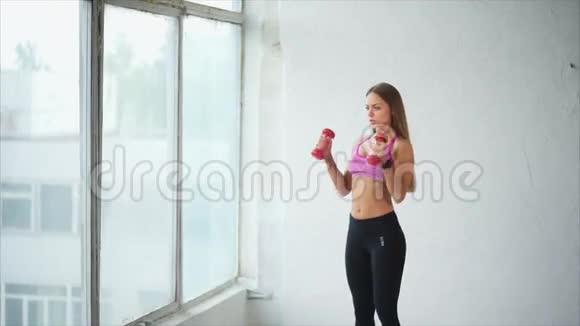年轻女子在健身俱乐部从事背部和手部的肌肉活动视频的预览图