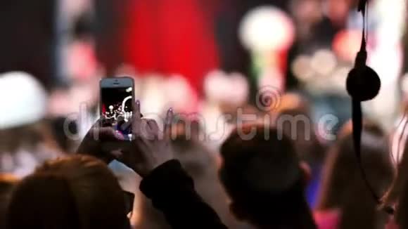 一个女孩在智能手机上拍摄舞蹈的特写镜头模糊的背景视频的预览图