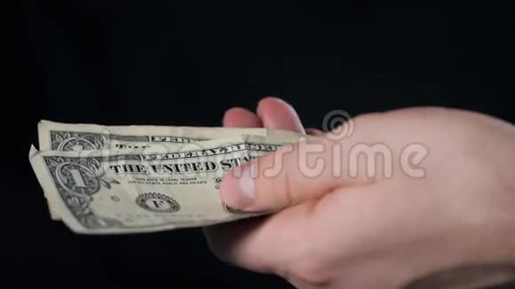 手与美元在黑色背景关闭视频的预览图