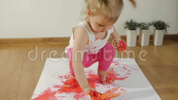 一个涂满油漆的小女孩在地上画着一张白纸视频的预览图