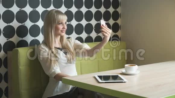 金发女孩用灰色手机自拍视频的预览图