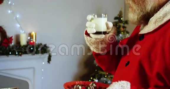 圣诞老人在椅子上放松喝牛奶视频的预览图