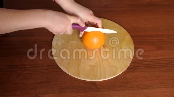 一个女人用刀子切橘子特写视频的预览图