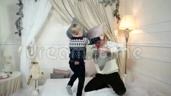 父亲好家庭幸福儿子陪爸爸玩枕头打架一个有爱心的父母花时间陪着开朗的儿子视频的预览图