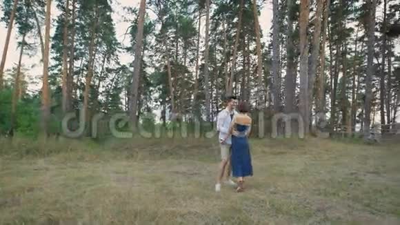 美丽的男人和女人站在松林中央的空地上拥抱视频的预览图