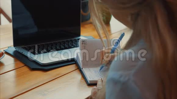 近距离观看商务女性使用笔记本和笔记本电脑的场景视频的预览图