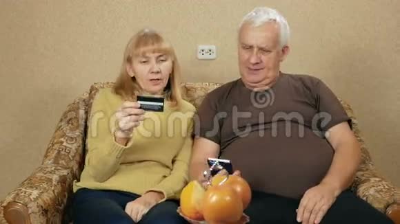 老年夫妇用银行信用卡支付在互联网上购买的费用女人决定数字男人进入视频的预览图