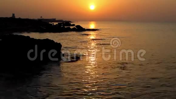 日出日落时海浪冲刷着石灰石海滩视频的预览图
