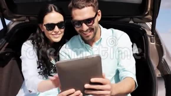 在掀背车后备箱2台平板电脑的幸福夫妇视频的预览图