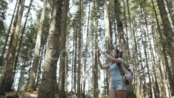 森林中快乐的女人的肖像女孩享受森林国家公园背包游客旅行生活方式视频的预览图