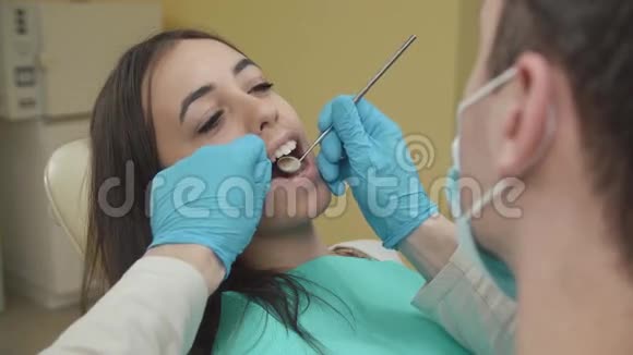 牙医在牙科办公室检查一名女性病人视频的预览图