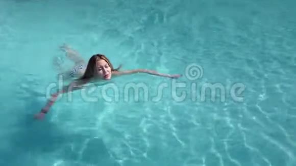 美丽的白种人模特年轻的女人正在一家酒店的游泳池里游泳在开阔的天空下概念视频的预览图