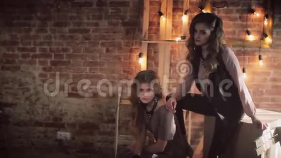 两个女孩在阁楼内部砖墙灯具木框和立方体视频的预览图