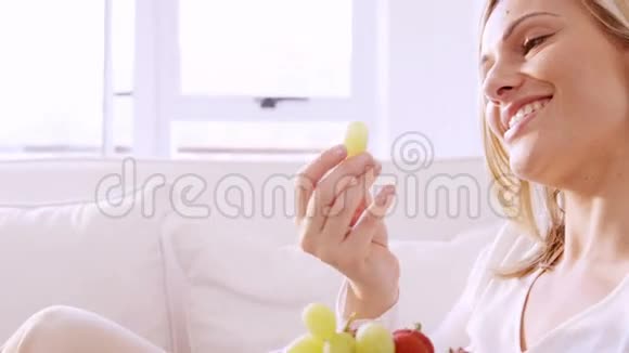 坐在沙发上吃水果的女人视频的预览图