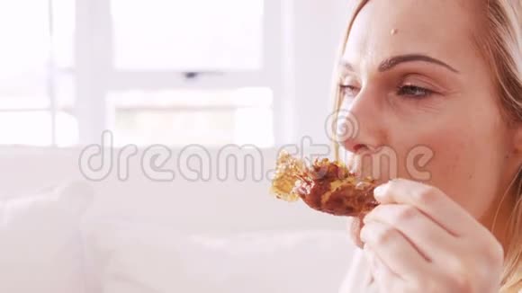 坐在沙发上吃鸡腿的女人视频的预览图
