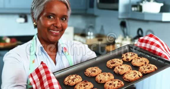 一位老妇人拿着一个托盘厨房里放着自制的饼干视频的预览图