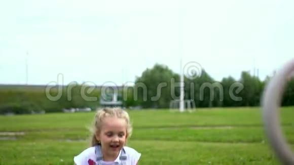 小女孩金发在河边公园的秋千上摇晃视频的预览图