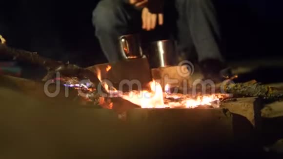 在晚上的营火里烧篝火在水壶里煮饭旅行徒步旅行冒险生活视频的预览图