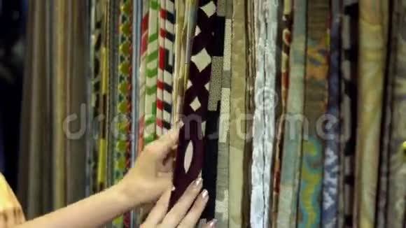 两名妇女在办公室讨论织物样品女孩在一堆纺织品上和顾客交谈视频的预览图