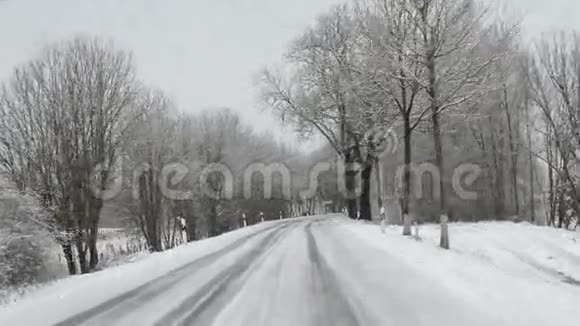 在冬天沿着一条路行驶雪和滑视频的预览图