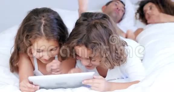 孩子们一边玩平板电脑一边和父母说话视频的预览图