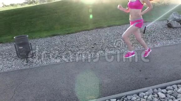 女子健身常规运动女跑步者沿宽路角慢跑慢动作视频的预览图