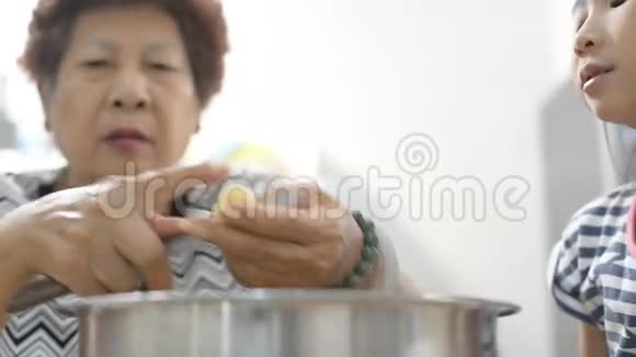 亚洲的老妇人和女孩一起在厨房做饭视频的预览图