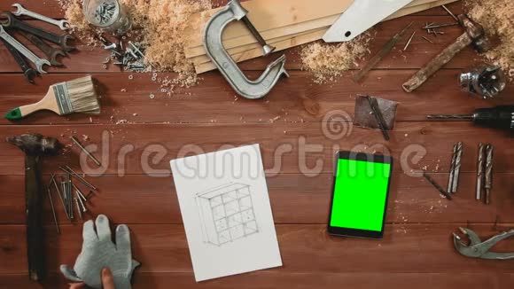顶层工匠手画橱柜草图数码平板绿屏躺在书桌上视频的预览图