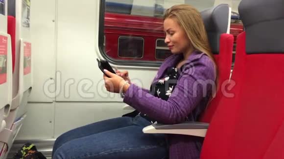 年轻漂亮的女孩坐在地铁里用平板电脑视频的预览图