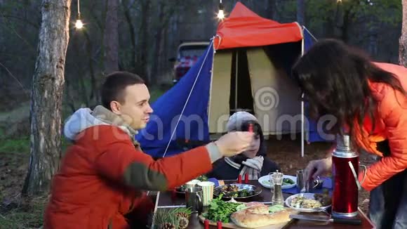 快乐的年轻家庭在秋天的森林里野餐视频的预览图