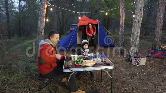 快乐的一家人在秋天的森林里野餐视频的预览图