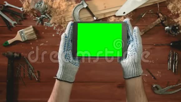 顶景工匠手拿手套手拿数字平板水平与绿色屏幕视频的预览图