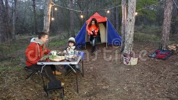 快乐的一家人在秋天的森林里野餐视频的预览图