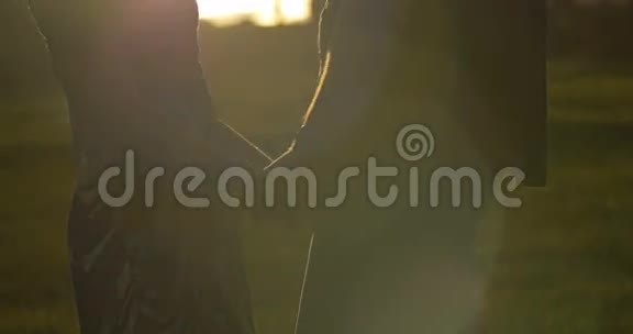 牵着手写真年轻夫妇爱公园日落慢动作生活方式视频的预览图