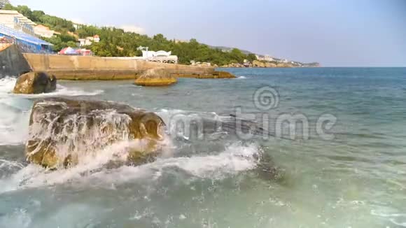 缓慢的海浪拍打着蓝天上的岩石视频的预览图