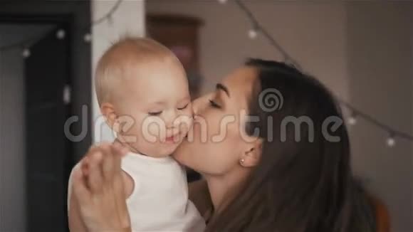 一幅快乐的年轻母亲带着孩子在家亲吻和欢笑的肖像视频的预览图