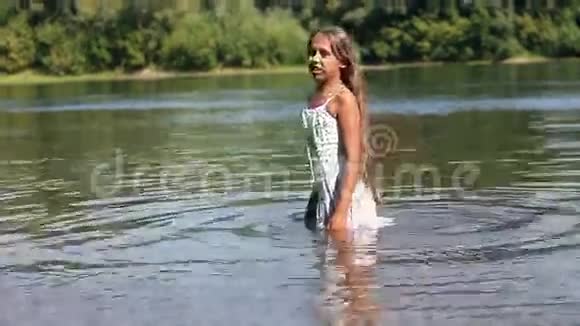 穿着白色裙子的女孩站在河里视频的预览图